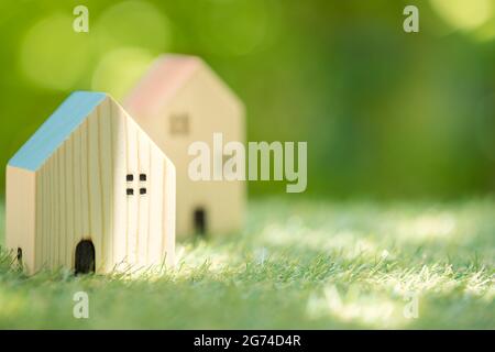 Kleines Holzhaus in grüner Natur Hintergrund für Öko-Haus Dorf Gemeinschaft Postkarte Banner Bild. Stockfoto