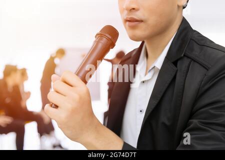 Nahaufnahme Mikrofon mit männlicher Hand im Seminar. Sprecher Mann Vortrag Meeting oder Talk Show Konzept. Stockfoto