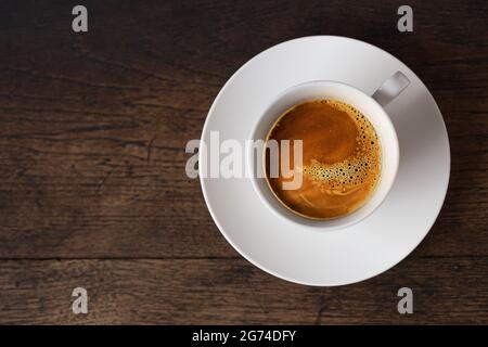 Dunkelrost Espresso Kaffee auf weißer Tasse auf alten Holztisch Hintergrund mit Kopie Platz. Stockfoto