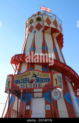 Helter Skelter auf der Rainbow Park Vergnügungsmesse in der Küstenstadt Hunstanton in Norfolk. Das Helter Skelter überblickt das Meer Stockfoto