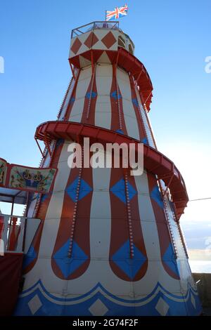 Helter Skelter auf der Rainbow Park Vergnügungsmesse in der Küstenstadt Hunstanton in Norfolk. Das Helter Skelter überblickt das Meer Stockfoto