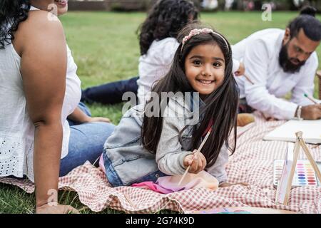 Happy indian Familie mit Spaß Malerei mit Kindern im Freien im Stadtpark - Main kleines Mädchen Gesicht Stockfoto