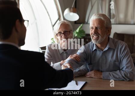 Glücklich dankbar ältere paar Kunden danken Immobilienmakler Stockfoto