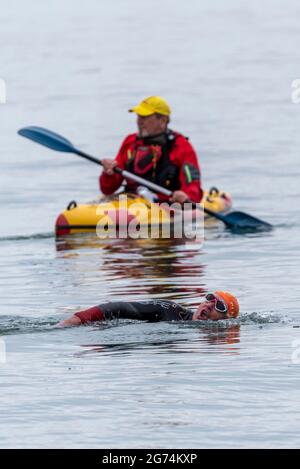 Sicherheitskanonist wacht über Schwimmer, die beim Southend Triathlon 2021 in Shoeburyness, Southend on Sea, Essex, Großbritannien, teilnehmen Stockfoto