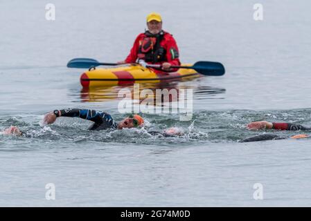 Sicherheitskanonist wacht über Schwimmer, die beim Southend Triathlon 2021 in Shoeburyness, Southend on Sea, Essex, Großbritannien, teilnehmen Stockfoto