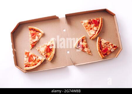 Leckere Pizzastücke im Lieferkarton auf weißem Hintergrund Stockfoto