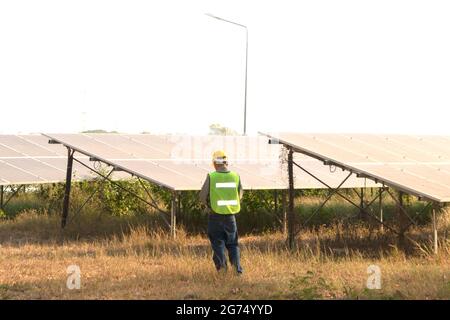 Männlicher Ingenieur mit Notizbuch und Arbeitsbericht zur Inspektion des Solarsystems. Im Freien. Konzept der Energietechnik-Industrie. Stockfoto