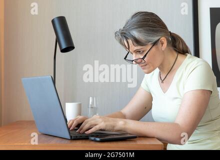 Frau mittleren Alters, die zu Hause arbeitet Stockfoto