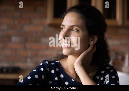 Glückliche nachdenkliche tausendjährige lateinische Frau genießen Pause zu Hause Stockfoto