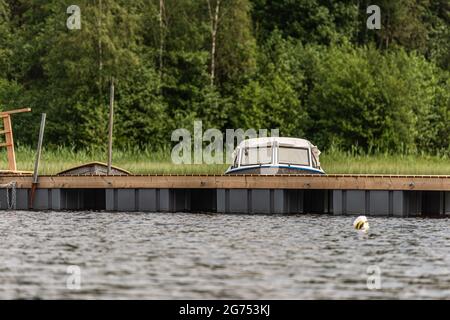 Kleiner Daycruiser, der an schwimmenden Docks festgemacht ist Stockfoto