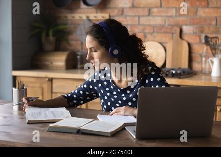 Fokussierte Studentin mit Kopfhörern und Laptop Stockfoto