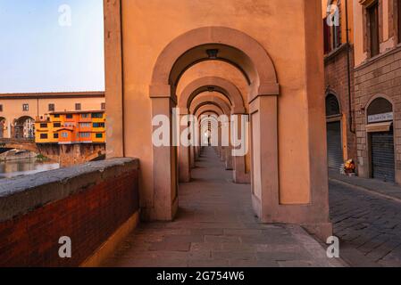 Corridoio Vasariano Passage, Florenz, Italien. Schöne symmetrische, warmgelbe Architektur. Vasari-Korridor. Ponte Vecchio im Hintergrund Stockfoto