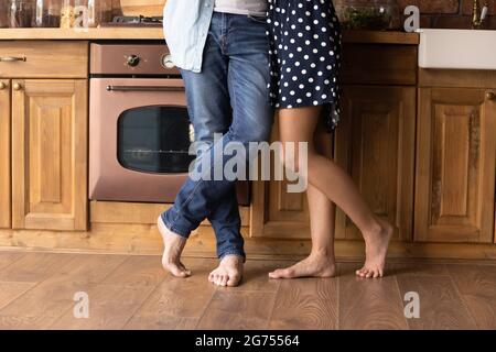 Beine eines jungen, barfuss gestandenen Paares auf dem Heizboden Stockfoto