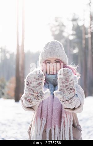 Winterfrau, die am kalten Wintertag im Schnee fröhlich aufschaut und lächelt Stockfoto