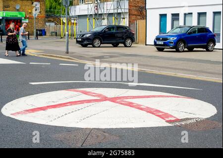 Dedworth, Windsor, Britannien. Juli 2021. Eine Reihe von Mini-Kreisverkehren in Dedworth, Windsor, wurden mit einem roten Kreuz bemalt, das wie die englische Flagge von St. George vor dem UEFA Euro 2020-Finale heute Abend zwischen England und Italien aussieht. Arbeiter für den Royal Borough of Windsor und Maidenhead kamen und bemalten die roten Kreuze, aber sie sind wieder erschienen. Quelle: Maureen McLean/Alamy Live News Stockfoto