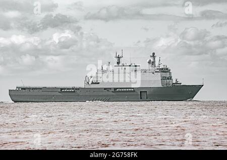 Großes graues modernes Kriegsschiff, das in stillem Wasser segelt. Stockfoto