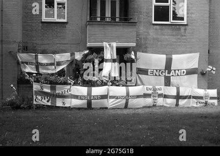 In ganz England zeigen die Menschen ihre Farben und wünschen sich eine Wiederholung der WM 1966. Ein Mann kleidet sein Haus in Flaggen, um England beim Gewinn der UEFA-Fußball-Europameisterschaft zu unterstützen. Stockfoto