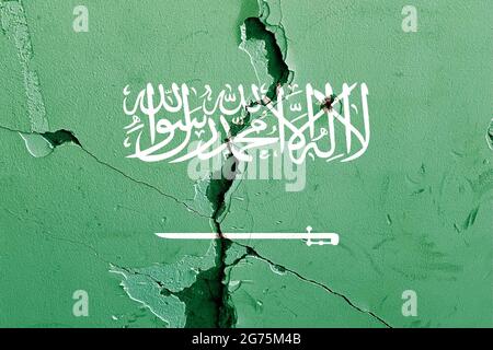 Die Nationalflagge Saudi-Arabiens malte auf eine verwitterte, gebrochene Mauer - politisches Konfliktkonzept Stockfoto