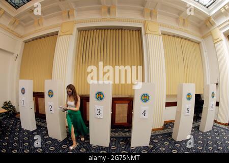 Bukarest, Rumänien. Juli 2021. Eine in Rumänien lebende moldauische Staatsbürgerin wählt in einem Wahllokal in Bukarest, Rumänien, am 11. Juli 2021 ihre Stimme. Rund 3 Millionen Wähler der Republik Moldau sind am Sonntag aufgerufen, ihre Stimme bei vorgezogenen Parlamentswahlen abzusetzen, bei denen 20 politische Parteien, zwei Blöcke und ein unabhängiger Kandidat gegeneinander antreten. Quelle: Cristian Cristel/Xinhua/Alamy Live News Stockfoto