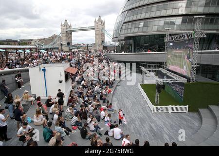 Das Tennisspiel der Männer von Wimbledon wird auf einer Großleinwand in der Nähe der Tower Bridge, London, vor dem UEFA Euro 2020-Finale zwischen Italien und England beobachtet. Bilddatum: Sonntag, 11. Juli 2021. Stockfoto