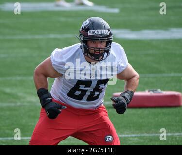 Ottawa, Kanada. Juli 2021. Offensivlineman Nolan McMillan (66) führt die Spieler durch Übungen, als die Ottawa REDBLACKS der Canadian Football League (CFL) ihr Trainingslager auf dem TD-Platz eröffnen, während sie die Saison 2021 eröffnen. Nachdem die CFL die gesamte letzte Saison aufgrund der Pandemie eingestellt hat, wird sie diese Saison gemäß dem genehmigten Protokoll spielen. Kredit: Meanderingemu/Alamy Live Nachrichten Stockfoto