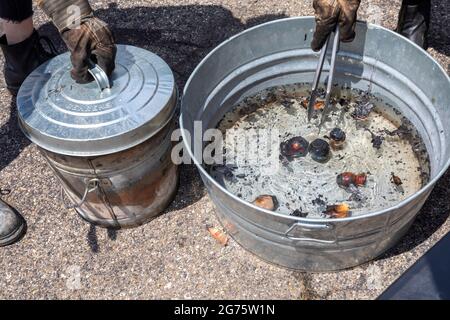 Detroit, Michigan - Mitglieder des Pewabic Pottery Street Teams demonstrieren die japanische Technik des Raku-Feuers von Töpferwaren auf einem Gemeinschaftskunstwerk und einem Mu Stockfoto