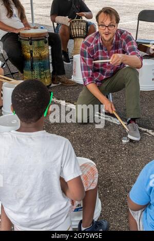 Detroit, Michigan - Jungen lernen auf einem Kunst- und Musikfestival Trommeln. Ben Piper, Musiklehrer an den Detroit Public Schools, leitet den wo Stockfoto