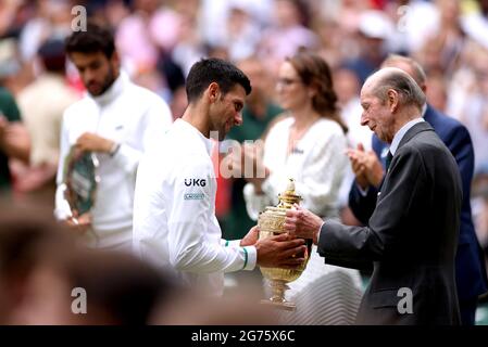 Der Herzog von Kent (rechts) überreicht Novak Djokovic seine Trophäe, nachdem er am dreizehnten Tag von Wimbledon im All England Lawn Tennis and Croquet Club in Wimbledon das Finale der Herren-Einzelspiele gegen Matteo Berrettini auf dem Mittelfeld gewonnen hat. Bilddatum: Sonntag, 11. Juli 2021. Stockfoto