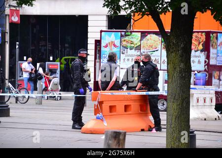 Polizeivorfall und Cordon in Piccadilly Gardens, Manchester, England, UK, am Sonntag, den 11. Juli 2021, um 15.13 Uhr. Polizisten sprechen mit einem Mann, der anscheinend Handschellen hat. Ein PCSO-Beamter dachte, der Vorfall sei ein Messerstecher, aber das ist nicht bestätigt. Stockfoto