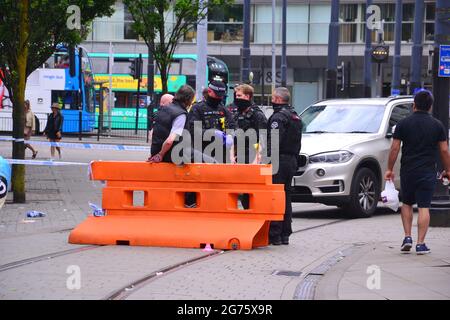 Polizeiereignis und -Absperrung in Piccadilly Gardens, Manchester, England, großbritannien, am Sonntag, den 11. Juli 2021, um 15.13 Uhr. Polizeibeamte sprechen mit einem Mann, der offenbar mit Handschellen gefesselt ist. Ein PCSO-Offizier dachte, der Vorfall sei ein Messer, aber das ist nicht bestätigt. Stockfoto