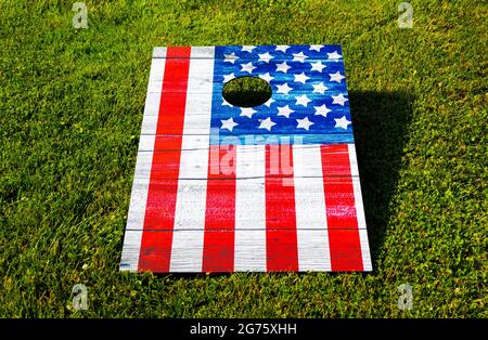 Rot weiß und blau Cornhole Spiel sieht aus wie eine amerikanische Flagge auf einem grünen Rasen. Stockfoto