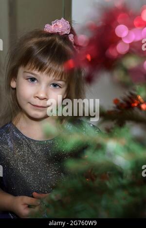 Porträt eines 4-5-jährigen Mädchens am weihnachtsbaum. Stockfoto