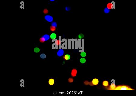 Farbige Bokeh-Lichter funkeln auf schwarzem Hintergrund. Stockfoto