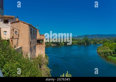 Der Ebro Fluss und die Stadt Miravet mit den alten Gebäuden, Provinz Tarragona in Spanien. Stockfoto