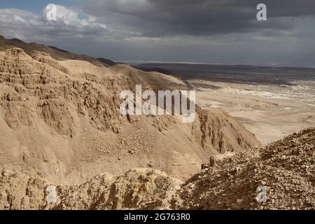 Malerische Aussicht auf die Schlucht des trockenen Flussbetts von Nachal Admon, die Judäische Wüste, die unter Herbstwolken in das Grabental fällt, Israel. Stockfoto