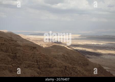 Blick von oben auf eine Schlucht von Nachal Admon, in der Judäischen Wüste, Verdunstungspools südlich des Toten Meeres, das Rift Valley, Edomite Heights und Herbstwolken gesehen Stockfoto