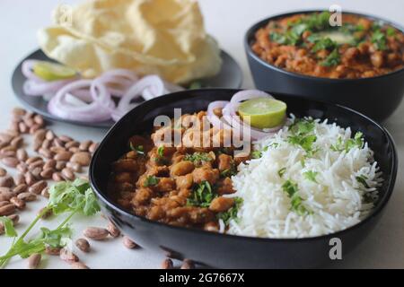 Rote Kidney Beans in einer dicken und würzigen Soße aus Zwiebeln und Tomaten serviert zusammen mit gedämpftem Basmati-Reis und Papad. Allgemein bekannt als rajma masala an Stockfoto