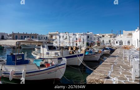 Griechenland, Paros Insel Naousa alten Hafen. Kykladen. 20.Mai 2021. Typische Fischerboote, die am Hafendock festgemacht sind, traditionelle Cafés und Tavernen im Freien, s Stockfoto