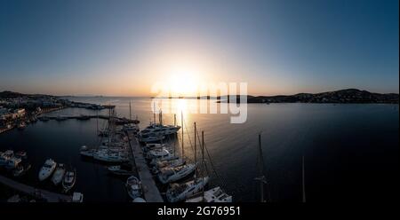 Griechenland, Insel Paros. Kykladen. 25.Mai 2021. Parikia Hafen Marina Luftdrohne Ansicht bei Sonnenuntergang. Die Sonne fällt über das ruhige Meer, die Boote vertäuten am Hafen. Stockfoto