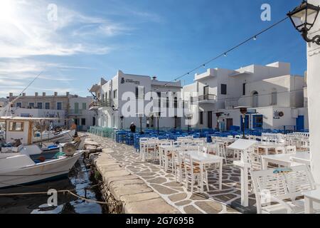 Griechenland, Paros Insel Naousa alten Hafen. 20.Mai 2021. Kykladen. Typische Fischerboote, die am Hafendock festgemacht sind, traditionelle Cafés und Tavernen im Freien, c Stockfoto