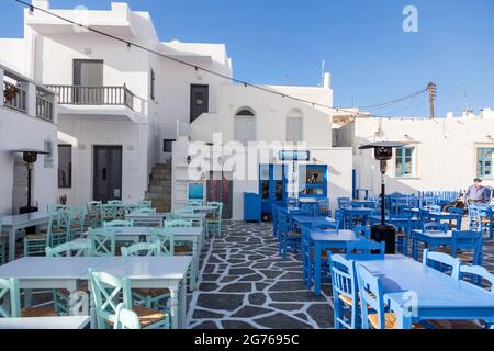 Griechenland, Paros Insel Naousa alten Hafen. 20.Mai 2021. Kykladen. Traditionelle Café-Bar und Taverne im Freien. Blaue leere Tische und Stühle, griechischer Fischerboss Stockfoto