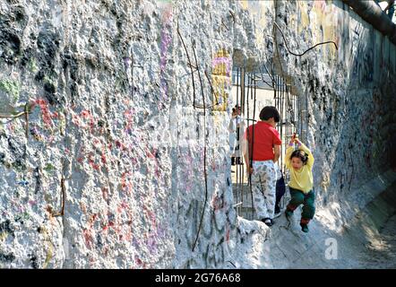 Berlin, Deutschland. 20. April 1990. Kinder spielen an einem Abschnitt der Berliner Mauer, der von Souvenirjägern abgeplatzt wurde, am 20. April 1990 in West-Berlin. Die Mauer zwischen Ost- und Westdeutschland fiel am 9. November 1989. Stockfoto