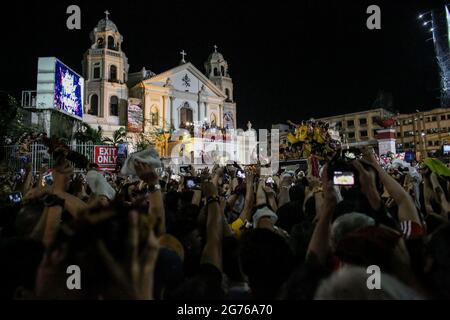 Die Kutsche des Schwarzen Nazareners bereitet sich darauf vor, während der Prozession zurück in die Kirche zu gehen, um ihren Festtag zu feiern, als er in Manila einfährt. Eine riesige Menschenmenge von meist barfuß-philippinischen Katholiken bete zu Beginn einer jährlichen Prozession einer jahrhundertealten schwarzen Statue Jesu Christi zu einem der größten religiösen Ereignisse Asiens für den Frieden im zunehmend unbeständigen Nahen Osten. Philippinen. Stockfoto