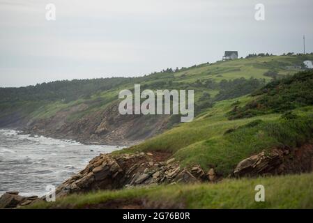 Ein dramatisch platziertes Haus auf einem Damm mit Blick auf den St. Lawrence entlang des Cabot Trail in Nova Scotia. Stockfoto