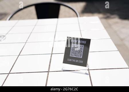 Menü anzeigen und QR-Code-Zeichen auf dem Tisch im Café scannen Stockfoto