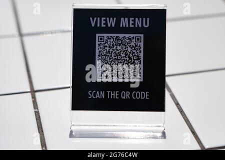 Menü anzeigen und QR-Code-Zeichen auf dem Tisch im Café scannen Stockfoto
