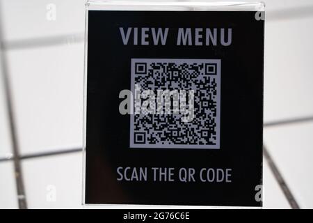 Menü anzeigen und QR-Code-Zeichen auf dem Tisch im Café scannen Stockfoto
