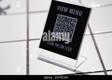 Menü anzeigen und QR-Code-Zeichen auf dem Tisch im Café scannen Stockfoto
