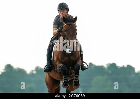 Raeford, North Carolina, USA. Juli 2021. AUSTIN SKEENS Reiten Was gibt, tritt im Stadionspringen bei der 2021 war Horse Event Series, Juli 11, im Carolina Horse Park in Raeford, N.C. an Die 2013 als Cabin Branch Event Series gegründete war Horse Event Series besteht aus fünf Pferdeversuchen und kombinierten Tests und zieht Reiter und ihre Pferde aus dem gesamten Osten der Vereinigten Staaten an. Quelle: Timothy L. Hale/ZUMA Wire/Alamy Live News Stockfoto