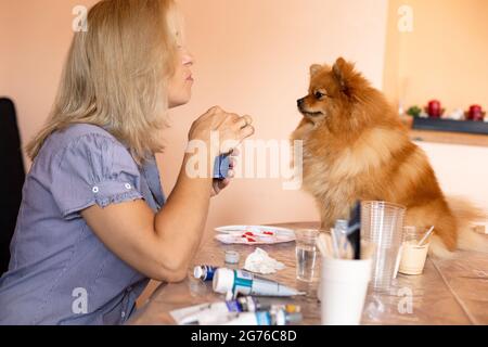 Wunderbare Momente des gegenseitigen Verständnisses und der Kreativität.die Künstlerin arbeitet mit ihrer Assistentin Spitz zusammen. Hobbys und Kreativität. Arbeiten Sie zu Hause. Happine Stockfoto